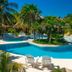 Portofino Beach Resort in San Pedro Town with a tropical lagoon-style pool and palm trees