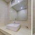 Hotel Daya Continental, New Delhi: modern bathroom with sink, mirror, and wall-mounted toilet
