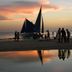 Sunset sailboats on Boracay beach reflected in shallow water near Azzurro Di Boracay Resort