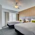 Homewood Suites by Hilton Louisville-East guest room with two beds and wood-accent wall in Louisville
