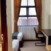 Uny Hotel Yogyakarta guest room with two beds, desk, chair and curtained window