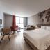 Ibis Styles Hyeres Centre Gare room with bed, sofa, desk and large window in Hyères
