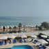 Santa Beach Hotel in Agía Triáda with poolside loungers and beach umbrellas overlooking the sea