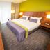 Fletcher Hotel-Restaurant De Buunderkamp guest room in Wolfheze with double bed, TV and window curtains