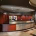 Courtyard by Marriott Fayetteville lobby front desk with wood paneling and curved stone reception counter