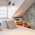 Cotswold Plough Hotel & Restaurant in Bampton bedroom with skylight, exposed stone wall and bedside lamp