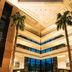 Sheraton Pilar Hotel & Convention Center lobby atrium with tall palm trees, glass walls and seating in Pilar