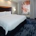 Fairfield Inn & Suites by Marriott Seattle Bremerton guest room with king bed, lamp, and window curtains