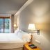 Abba Xalet Suites Hotel in Sispony room with bed, wall-mounted TV, and balcony mountain view