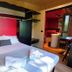 Concept Village Piccola Gardiola room with bed, red accent wall, and terrace view in San Felice del Benaco