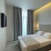 Palladion Boutique Hotel in Árgos bedroom with king bed, tall window, and warm ceiling lighting