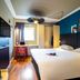 ibis Aulnay Paris Nord Expo room with double bed, desk by window, wall TV and colorful accent wall