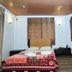 Ashley Resort in Nuwara Eliya guest room with bed, red sofa, and coffee table with flowers