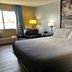 Super 8 by Wyndham Estherville guest room with king bed, armchair, lamps and window