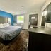 Red Carpet Inn Orchard Park guest room with king bed, TV, desk, and window in Orchard Park