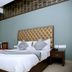 Hotel Park Plaza in Chandigarh guest room with king bed, tufted headboard, window AC and seating area