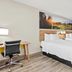 Days Inn by Wyndham Fontana / Rialto room with two double beds, desk, and bathroom doorway in Rialto