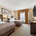 Best Western Plus St. Albert guest room with two beds, TV, desk and window with sheer curtains