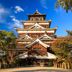 Hiroshima Ekimae Green Hotel in Hiroshima near a traditional Japanese castle under a blue sky
