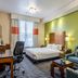 Fairfield Inn & Suites by Marriott Alamogordo guest room with bed, sofa, desk, and green accent wall