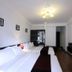 Hanoi Crystal Hotel in Hanoi guest room with twin beds, wall-mounted TV and dark wood flooring