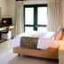 Sandton Lodge Rivonia in Johannesburg guest room with bed, desk, armchair and TV near bright window