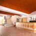 Hotel Maria de Lourdes in Cancún lobby with reception desk, staircase, and terracotta tile floor