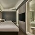 Vibe Hotel Singapore Orchard guest room with twin beds, wall-mounted TV and bathroom view