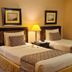 Herald Suites Solana Makati twin guest room with two single beds and bedside lamp
