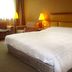Rosedale Hotel Shenyang guest room with king bed, armchairs and bedside lamps in Shenyang