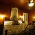 Swantown Inn & Spa in Olympia: cozy bedroom with wrought-iron bed, warm lighting, and ceiling fan