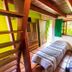 Pouso Sambaquis in Ilhabela with two single beds and a wooden loft ladder in a bright guest room