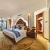 Jingland Exhibition Hotel in Xishuangbanna guest room with king bed, sitting area, and large window view