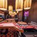 Grandhotel Brno in Brno: stylish casino room with gaming tables, slot machines and hanging pendant lights