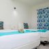 Hotel Maria de Lourdes in Cancún: bright twin room with turquoise bed runners and patterned curtains