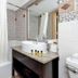 Best Western Plus Yacht Harbor Inn bathroom with tub-shower combo, sink vanity, and patterned tile walls in Dunedin
