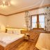 Naturhotel Reissenlehen in Berchtesgaden: cozy double room with wood floors, bed, and two windows