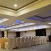 Silvercloud Hotel And Banquets Ahmedabad banquet hall with rows of covered chairs and blue ceiling lights