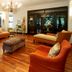 Sandton Lodge Rivonia in Johannesburg lounge with orange armchairs, sofa, chandelier and wood floors