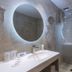 Hotel Sorra Daurada Splash bathroom with round mirror, sink, shower and frosted glass partition in Malgrat de Mar