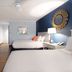 Banana Bay Resort & Marina in Marathon guest room with two beds, TV, nightstand lamp, and blue accent wall