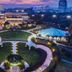 Parkyard Hotel Jiaxing in Jiaxing, aerial view of illuminated gardens, tents and city skyline at dusk