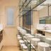 El Palauet Modernist Suites Barcelona bathroom with double sinks, mirrored wall and glass shelving in Barcelona.
