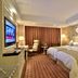 Zhong'an Huana Holiday Hotel in Hangzhou guest room with two twin beds, TV, seating area and warm lighting