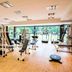 Sheraton Pilar Hotel & Convention Center gym with exercise machines and floor-to-ceiling windows overlooking greenery.