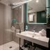 Novotel Nice Aéroport Cap 3000 bathroom with glass shower, vanity sink, and towels in Saint-Laurent-du-Var