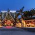 Jingland Exhibition Hotel in Xishuangbanna at dusk, with grand entrance, palm trees and lit pathway