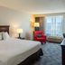 Country Inn & Suites by Radisson, Doswell, VA guest room with king bed, red armchair and desk by window