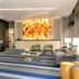 Hilton Motif Seattle lobby with colorful mosaic art, lounge chairs, sofas, and striped carpet