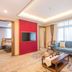 Desheng Hotel in Beijing suite with living area, sofa, TV, coffee table and bedroom doorway